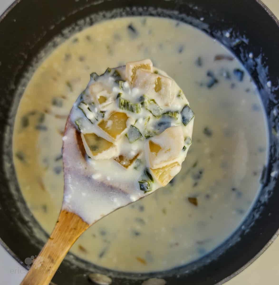 spoon holding prepared sauce over saucepan