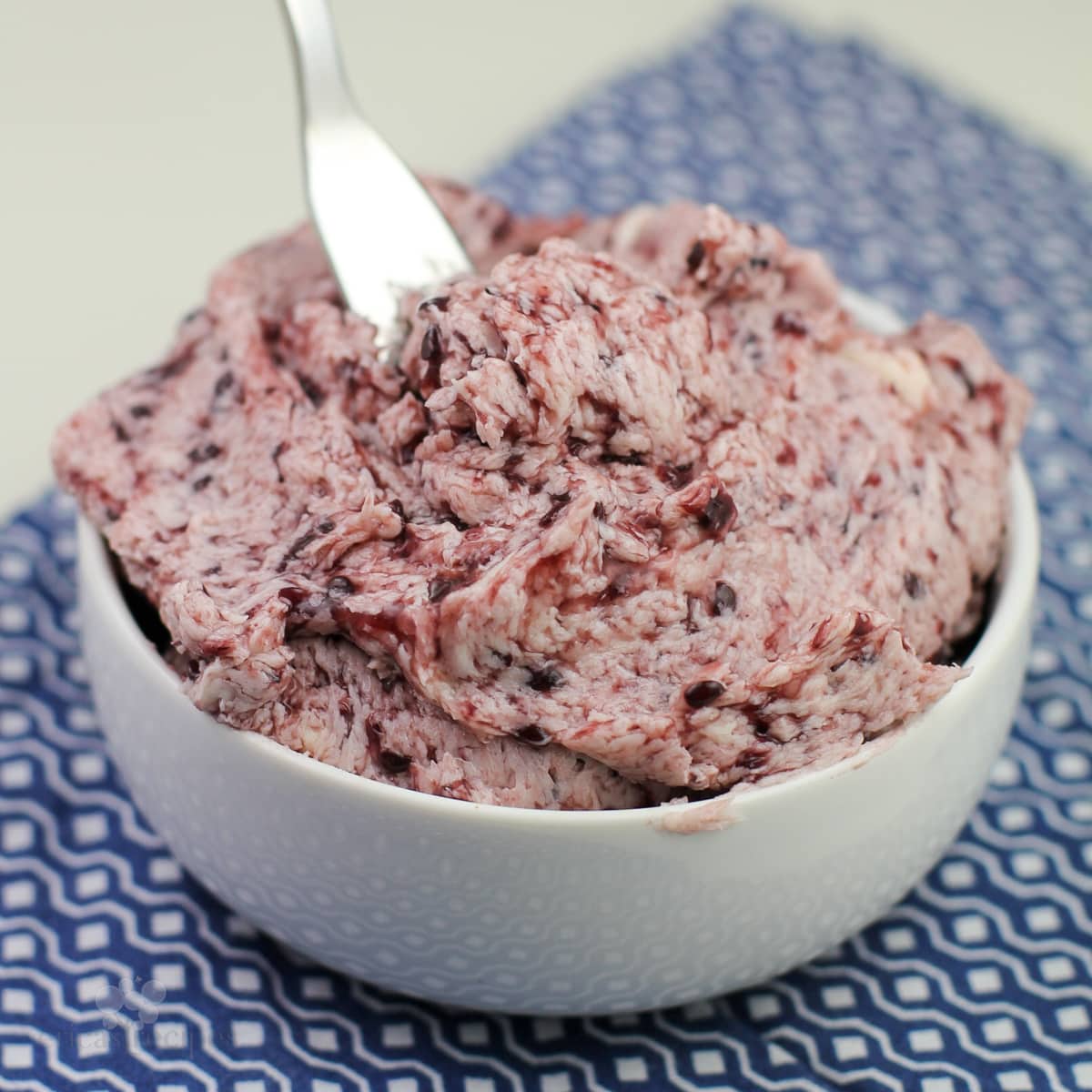 blackberry butter in white bowl on blue napkin