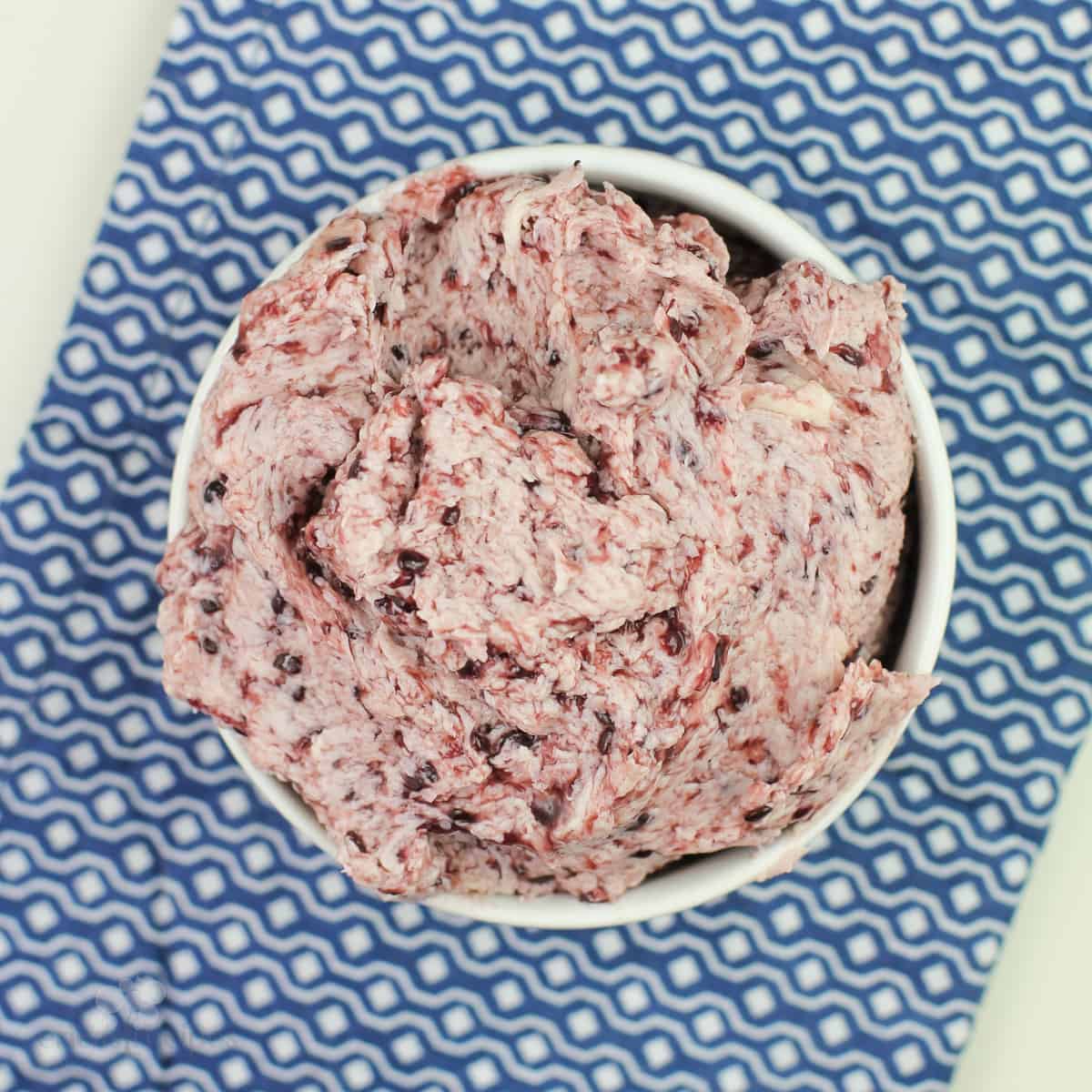 blackberry butter in white bowl on blue napkin