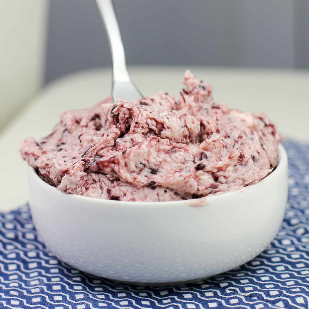 blackberry butter in white bowl on blue napkin