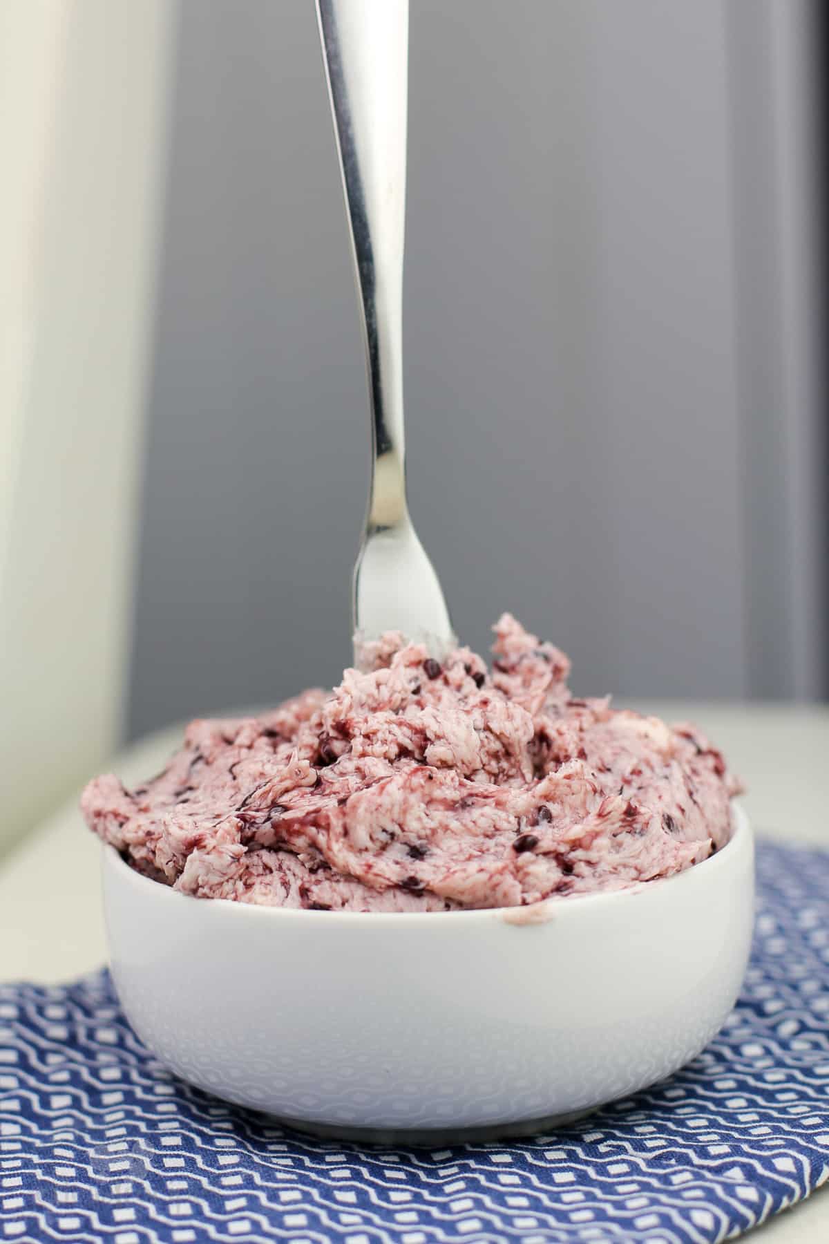 blackberry butter in white bowl on blue napkin